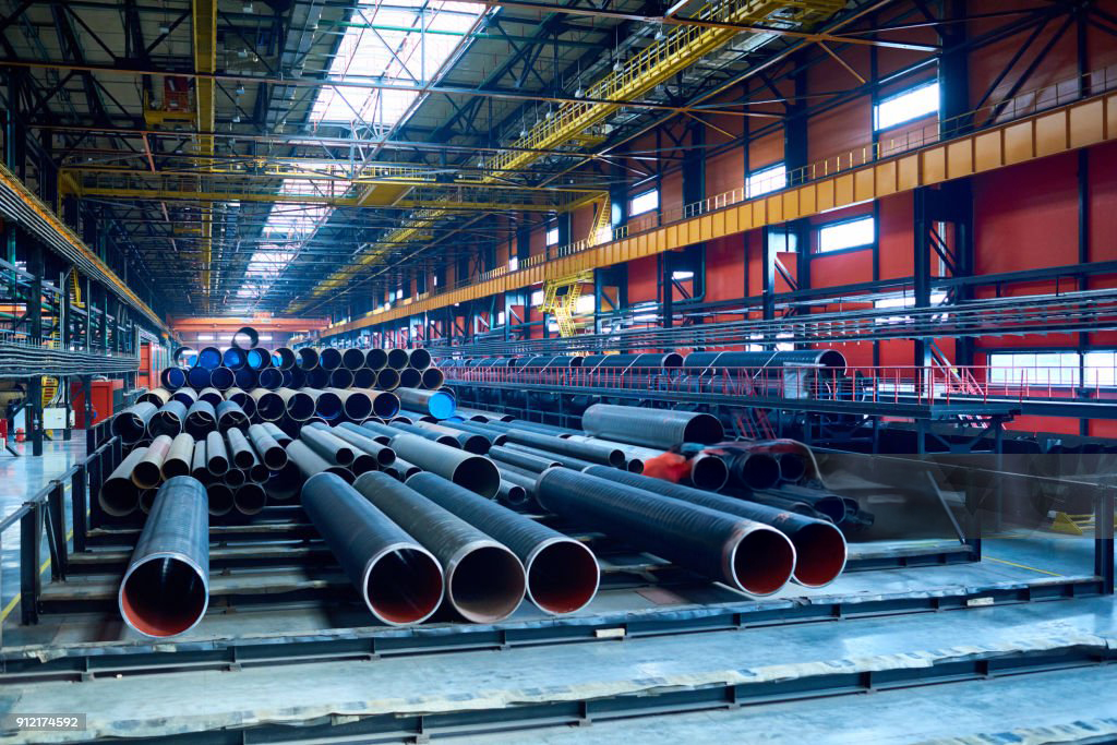 Abundance of tubes used for oil and gas industry placed in factory warehouse